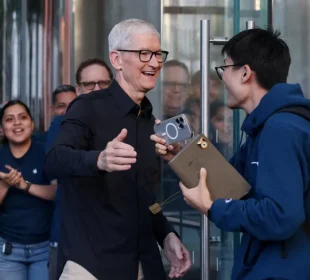 الرئيس التنفيذي لشركة أبل تيم كوك يحيي أحد العملاء بالتزامن مع طرح سلسلة هواتف آيفون 17للبيع، في متجر أبل بمدينة نيويورك، الولايات المتحدة. 19 سبتمبر 2025 - REUTERS